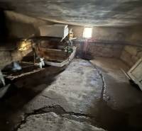 A cellar in a family house in Demandice with stone walls and simple lighting.