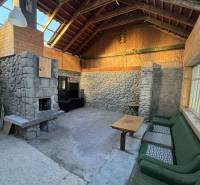 Interior of a family house with a stone fireplace and wooden paneling.