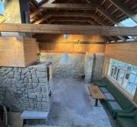 Stone walls, wooden ceiling, and seating in a family house.