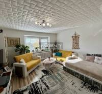 Living room in a two-room apartment with a wooden decor floor and comfortable seating.