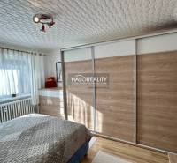Bedroom in a 2-room apartment with wood-patterned flooring and a large built-in wardrobe.
