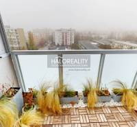 Balcony of a 3-room apartment in Bratislava - Ružinov with a view of the misty city, wooden floor decor.