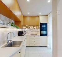 A kitchen in a 3-room apartment with a white kitchen unit, a stainless steel sink, and built-in appliances.