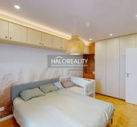 A bedroom in a 3-room apartment with built-in wardrobes, a bed, and a crib.