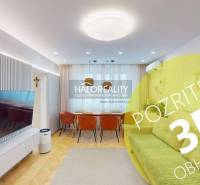 Living room in a 3-room apartment with a television, sofa, and wooden floor decor.