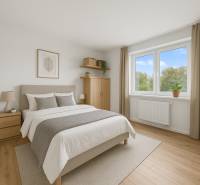 Bright bedroom in a 2-room apartment with wood-patterned flooring and a large window.