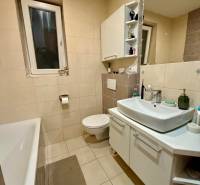 A bathroom with a bathtub and a white sink in a 2-room apartment.
