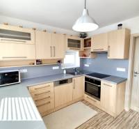 A kitchen in a family house with a wooden decor and a gray countertop.