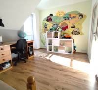 Children's room in a family house with a wooden decor floor and a cheerful wall mural.