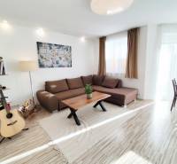 Living room in a family house with a large sofa and a floor with a wooden decor.
