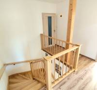 Inside the family house, there are wooden stairs and a floor with a wooden decor.