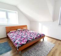 Bedroom with a bed and wooden decor flooring in a family house.