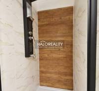 Shower corner with a wooden decor floor and marble tiles in a family house.