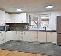 A kitchen in a family house with modern appliances and a wooden decor floor.