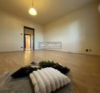 A room with a wooden decor floor in a 3-room apartment, lighting, light-colored walls.