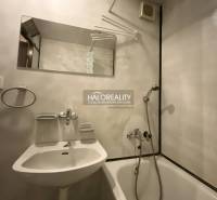 Bathroom in a 3-room apartment with a bathtub, mirror, and white sink.