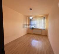 Empty room with a window, curtain, wood-patterned floor, light, and radiator.