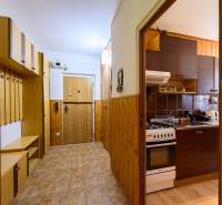 Hallway and kitchen in a 2-room apartment with wooden decor and storage spaces.