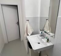 Bathroom in offices with a sink, towels, and cleaning supplies.