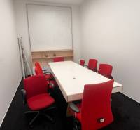 Offices with a white desk, red office chairs, and a black carpet.