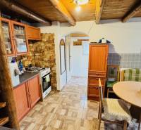 Rustic kitchen in a cottage with wooden floor decor and wooden ceiling.