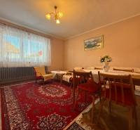 Living room in a family house with a carpet, wooden furniture, and a floor with a wood decor.