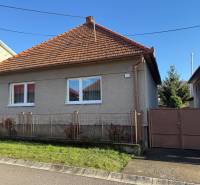 A family house in Machulince with a red tiled roof, white windows, and a garden.