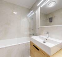 Bathroom in a 3-room apartment with tiles, a bathtub, a sink, and a mirror.