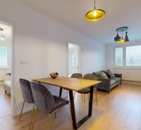 Interior of a 3-room apartment with a wooden decor floor, dining table, and sofa.