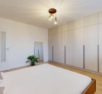 Bedroom in a 3-room apartment with a large wardrobe and a wooden decor floor.