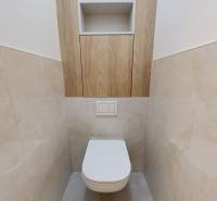 A toilet with ceramic tiles and storage space in a 3-room apartment.