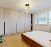 Bedroom in a 3-room apartment with a large wardrobe and a floor with a wooden decor.