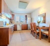 A kitchen in a 2-room apartment with a wooden decor and a dining table.