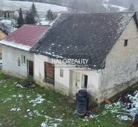 A family house in Klenovec with an older roof and a snow-covered plot.