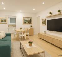 Living room in a 4-room apartment with a wooden decor floor, sofa, and table.