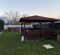 A wooden gazebo and a pool in the garden of a 3-room apartment in Boleráz.