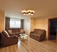 Living room in a 3-room apartment with sofas and a wooden decor floor.