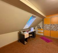 Attic room in a 3-room apartment with a desk and built-in wardrobe.