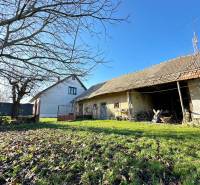 The yard of a family house on Podzáhradná Street in Iža, with an older wooden building.