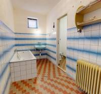 A bathroom in a family house with blue and white tiles and a bathtub.