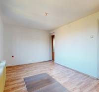 A room in a family house with a wooden decor floor and large windows.