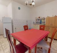 A kitchen in a family house with a white refrigerator, microwave, and dining table.