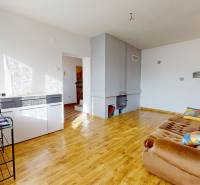 Living room of a family house with a sofa and a wood-patterned floor.