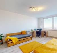 A bright room with a bed, a desk, and a wooden-patterned floor in a 3-room apartment.