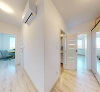 A hallway in a 3-room apartment with a wooden decor floor and a built-in wardrobe.