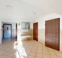 The entrance hall of a 3-room apartment with tiles and a fire extinguisher.