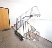 Entrance to a 3-room apartment with wooden doors and concrete stairs.
