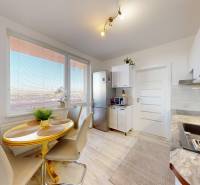 A kitchen in a 3-room apartment with a light floor and a dining table.