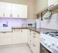 A kitchen in a 2-room apartment with rustic cabinets and a gas stove, bright design.