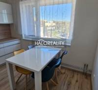 Dining area with a window in a 2-room apartment and a floor with a wooden decor.